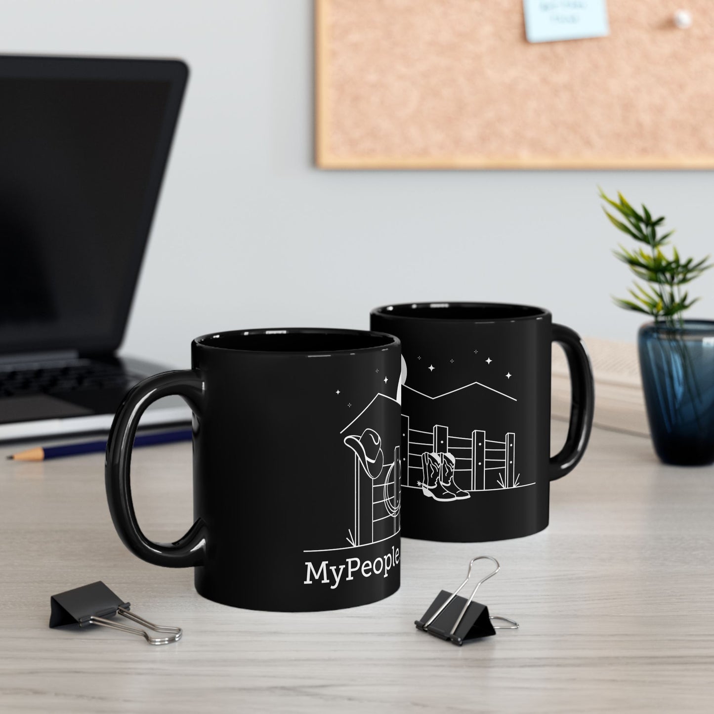 Two ceramic mugs featuring the MyPeople Cowboy line illustration sitting on a desk.