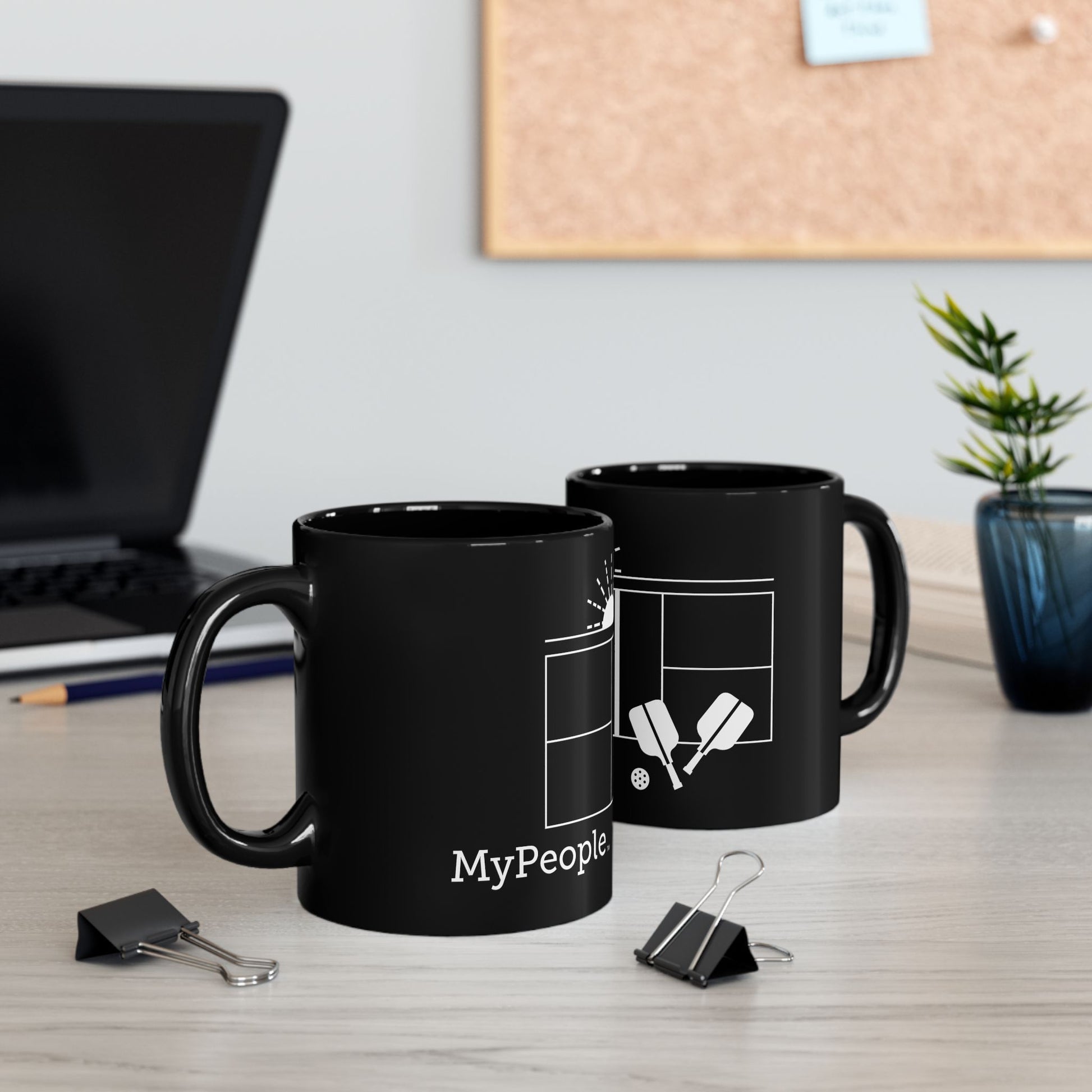 Two ceramic mugs featuring the MyPeople Pickleball line illustration sitting on a desk.