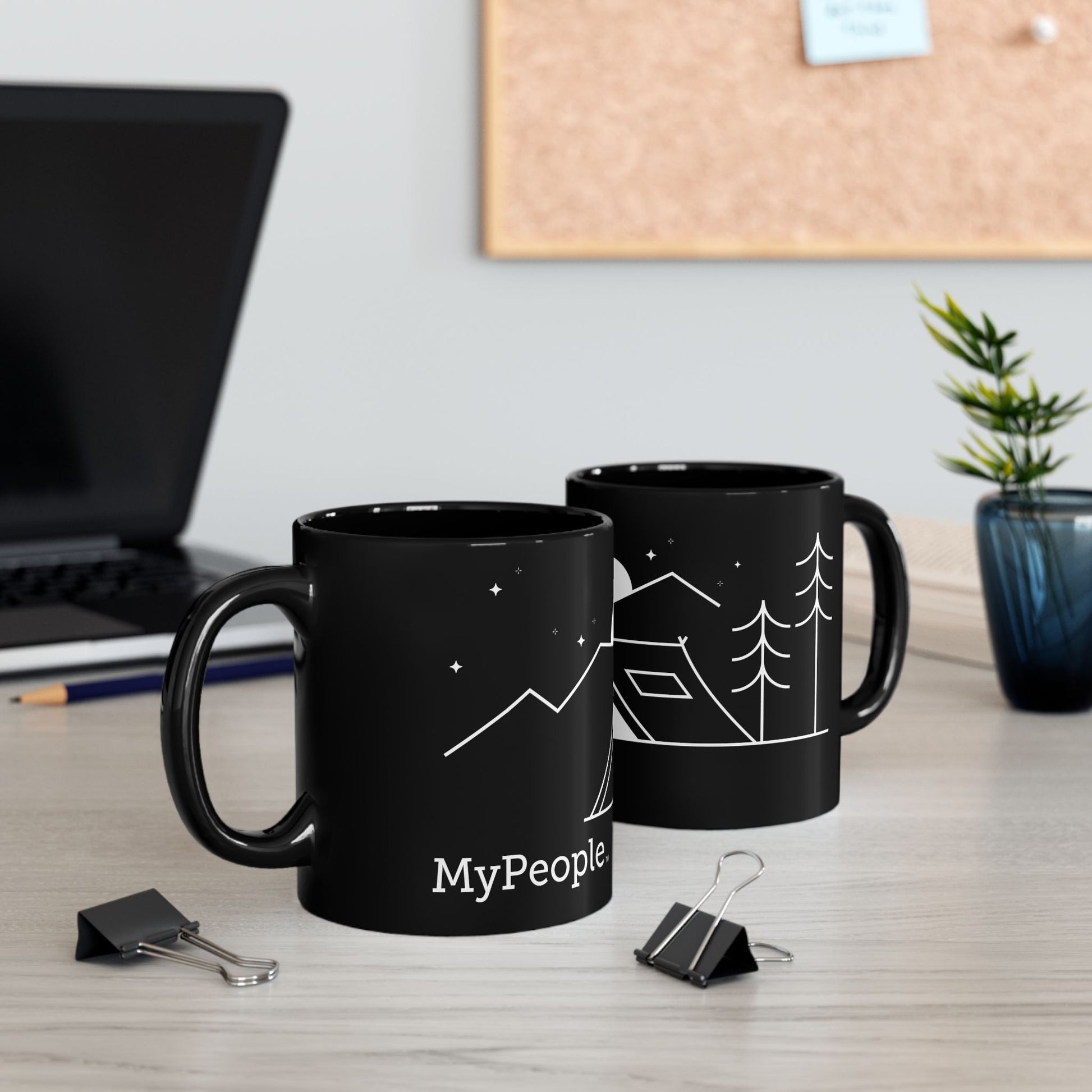 Two ceramic mugs featuring the MyPeople Tent Camping line illustration sitting on a desk.